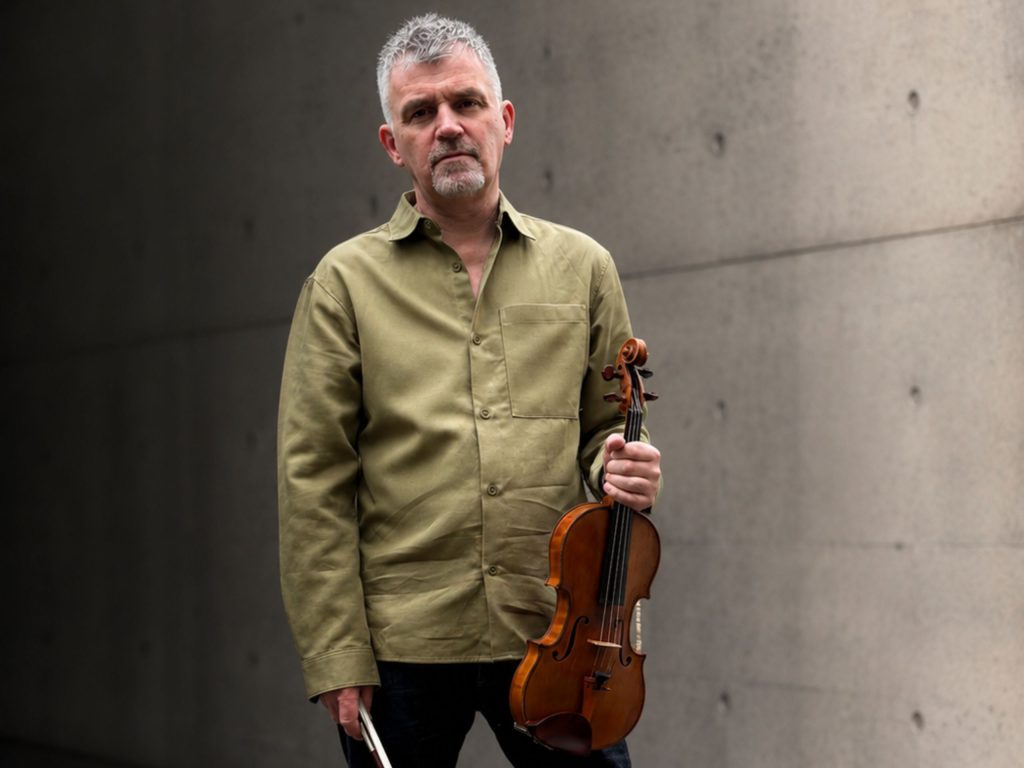 David Le Page standing in front of a brutalist looking building