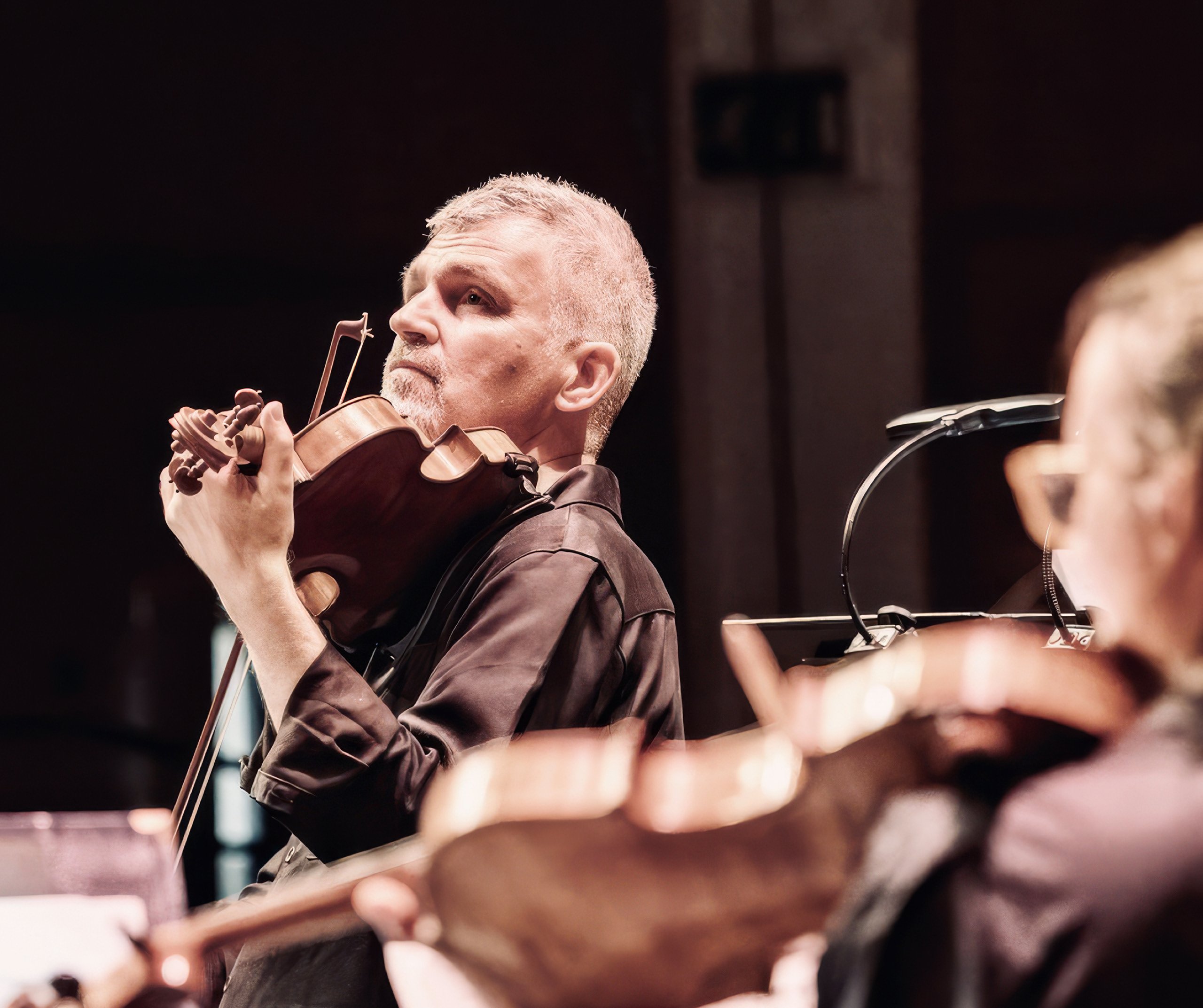 David Le Page playing violin in a concert setting